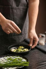 Male chef preparing for serving tasty ravioli on table