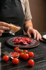 Male chef preparing for serving tasty ravioli on table