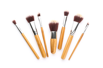 Set of professional makeup brushes on white background