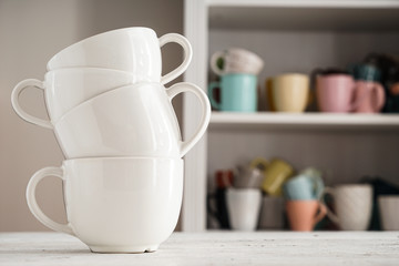 Stack of ceramic cups on white table