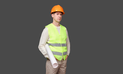 the man the builder in a helmet holds drawings, documents in hand, looks to the right