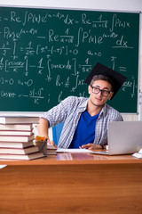 Young male student studying math at school