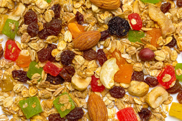 Granola, a breakfast dish containing rolled oats, nuts and honey, baked to a crispy state. On a white background.