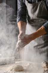 Young man preparing dough for bread in kitchen - obrazy, fototapety, plakaty