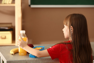 Fototapeta na wymiar Little girl having school lunch in classroom
