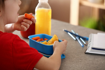 Little girl having school lunch in classroom