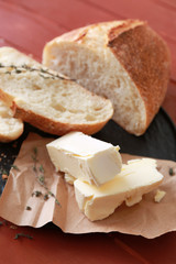 Plate with tasty butter and bread on table