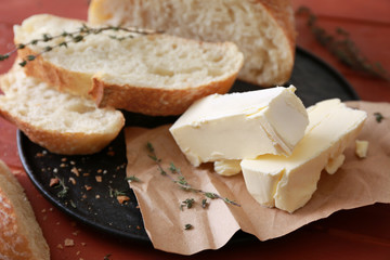 Plate with tasty butter and bread on table