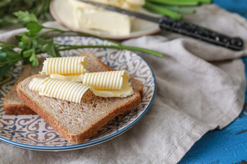 Fototapeta na wymiar Plate with tasty butter and bread on table, closeup