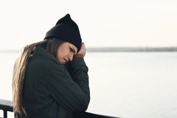 Young depressed woman thinking about suicide on bridge