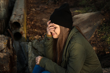 Young depressed woman thinking about suicide outdoors