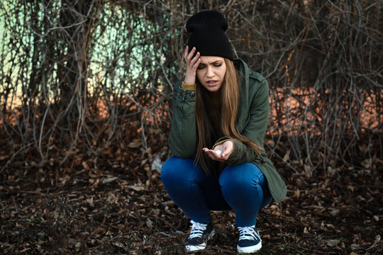 Young woman with pills is going to commit suicide outdoors