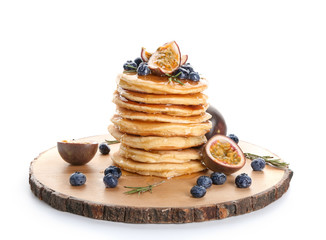 Tasty pancakes with passion fruit and berries on white background