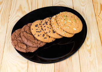 Various drop cookies on black dish on the wooden table