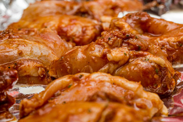 Close up of marinated chicken thighs on a silver foil lined baking tray ready for cooking