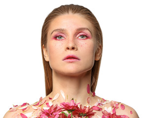 Fototapeta premium Beautiful woman with creative makeup and flowers on white background