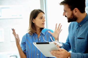 Young business couple with tablet in the office