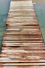 Fototapeta premium Old wooden bridge through the sea bay