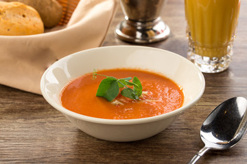 Pumpkin cream soup with glass of juice on a wooden table