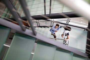 Young business people climb the stairs in the office