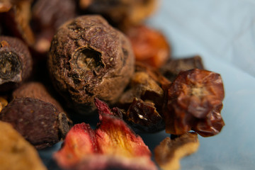 Dried berries tea - mixture of berries, close-up on blue background.