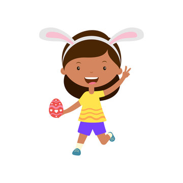 Cute laughing running girl with bunny ears holding egg in hand.Child hunting for easter eggs