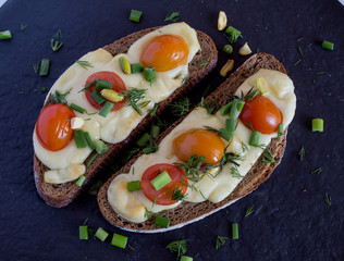 Multigrain toast bread with melt gouda or kaseri cheese and small tomatoes and green onion on top 