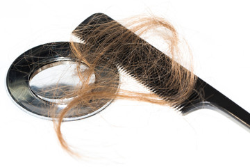 Hair loss on washbasin. Long brown hair with black comb on white basin in the bathroom.
