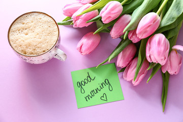 Bouquet of beautiful tulips, paper with text GOOD MORNING and cup of coffee on color background