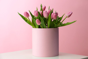 Box with bouquet of beautiful tulips on table