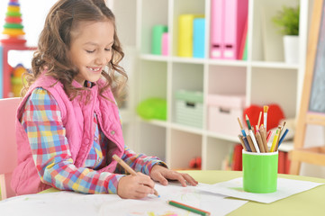 Portrait of cute beautiful smiling girl drawing at home