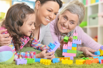 Obraz na płótnie Canvas Happy smiling family playing with colorful plastic blocks