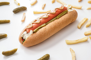 Tasty hot dog, pickled cucumbers and french fries on white background