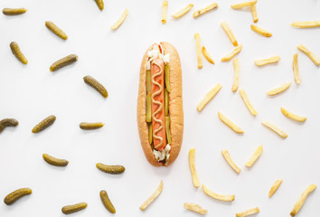 Tasty hot dog, pickled cucumbers and french fries on white background