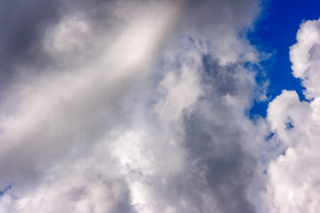 lush white cumulus clouds swim across the blue sky