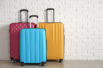 Packed suitcases near white brick wall