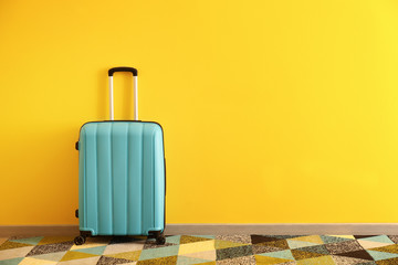 Packed suitcase near color wall