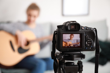 Young female musician recording video indoors