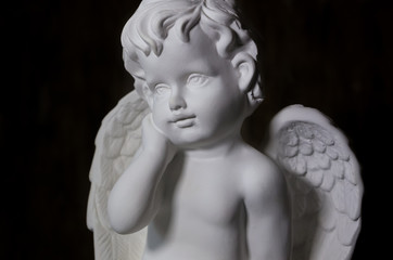 Beautiful white angel on black background close-up