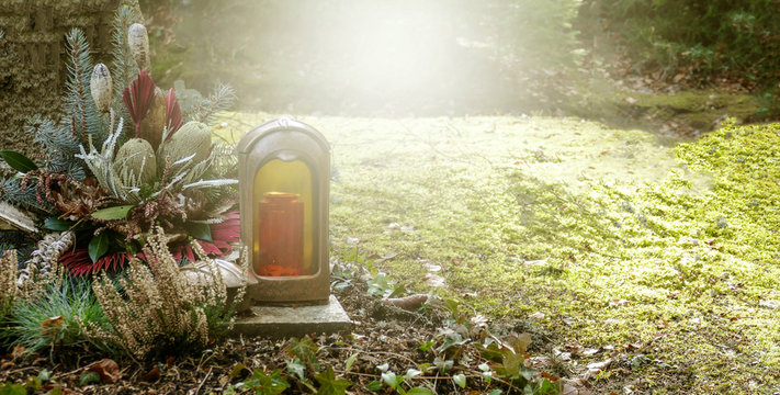 Herbstliches Gesteck und Kerze auf Grab im Friedhof - Tod, Trauer, Schmerz, Erl&ouml;sung