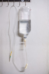 Saline solution iv bag with syringe line hanging on wall