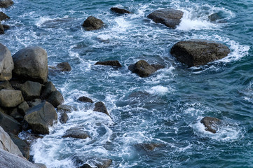Blue sea with wave hitting on rocks