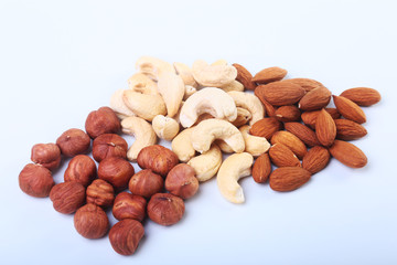 Mixed nuts from hazelnuts, almonds, cashews isolated on white background. Selective focus.