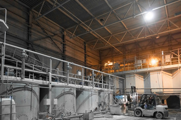 Fototapeta premium loader performs work in a dusty room at the plant