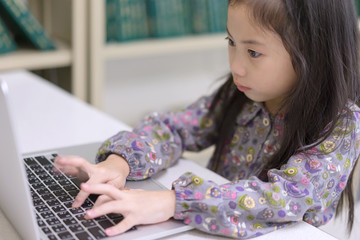 Fototapeta na wymiar Cute child girl using computer laptop.