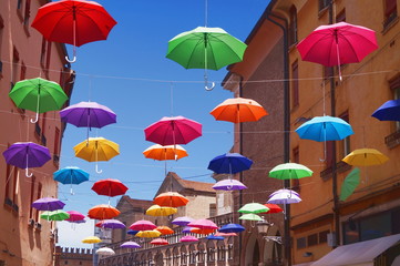 Fototapeta na wymiar Giuseppe Mazzini street with hanging umbrellas, Ferrara, Italy