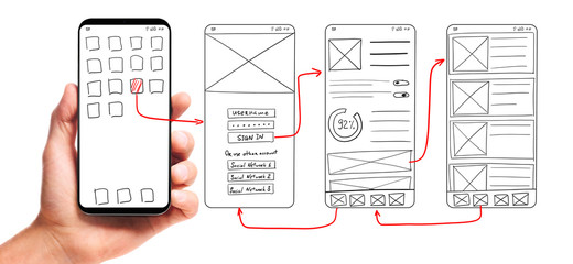 UI development. Male hand holding smartphone with wireframed user interface screen prototypes of a...
