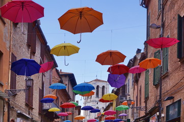 Fototapeta na wymiar Giuseppe Mazzini street with hanging umbrellas, Ferrara, Italy