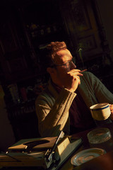 Young man writing on old typewriter.