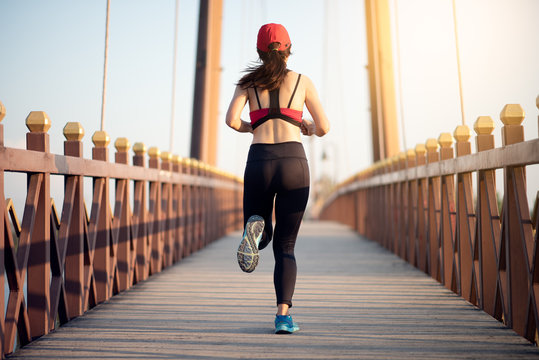 Young Asian woman runner running on the bridge in the morning